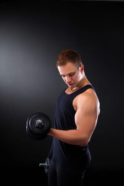 Handsome muscular man working out with dumbbells — Stock Photo, Image