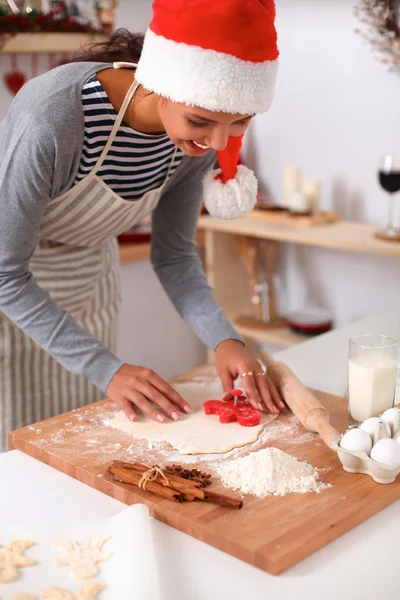 Žena dělá vánoční sušenky v kuchyni — Stock fotografie