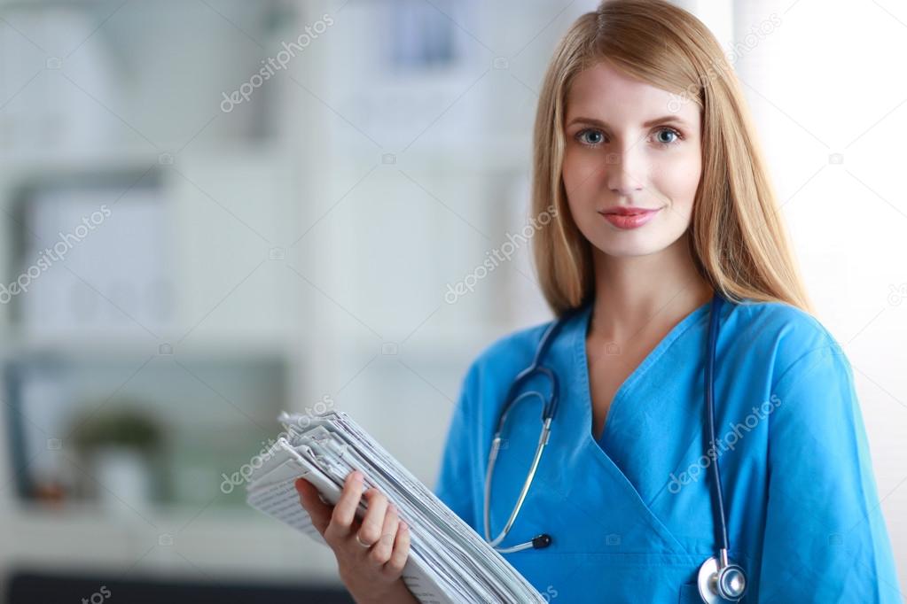Portrait of woman doctor with folder at hospital corridor