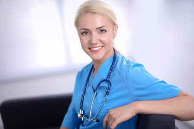 Kanepede oturan mutlu genç bir doktorun portresi.