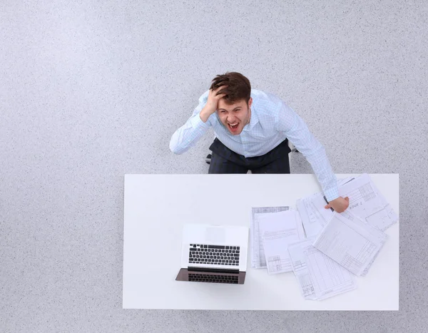 Joven trabajando en el ordenador portátil, sentado en el escritorio en la oficina —  Fotos de Stock