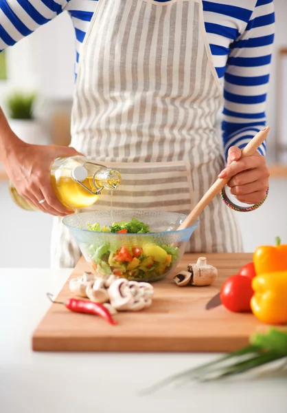 Jonge vrouw mengt verse salade — Stockfoto