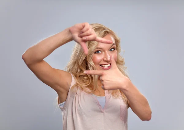 Young woman creating a frame with fingers — Stock Photo, Image