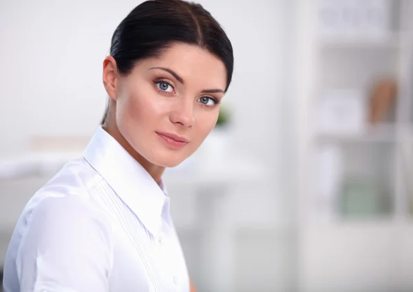 Attraktive Geschäftsfrau sitzt auf Schreibtisch im Büro — Stockfoto