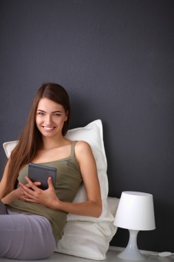 bir yastık ve uçak tablo ile katta oturan güzel esmer kadın