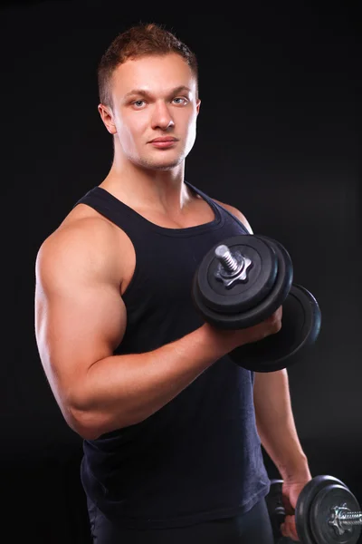 Schöner muskulöser Mann, der mit Hanteln trainiert — Stockfoto