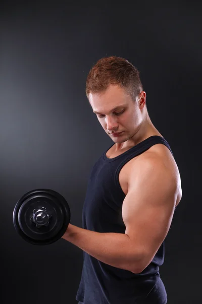 Schöner muskulöser Mann, der mit Hanteln trainiert — Stockfoto