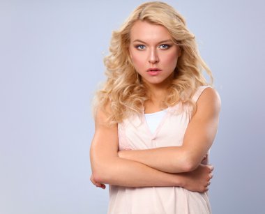 ayakta, gri arka plan üzerinde izole genç kadın