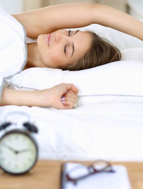 Genç bir kadın sabah alarmını erteliyor.