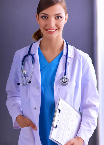 Médecin femme avec stéthoscope isolé sur fond gris — Photo