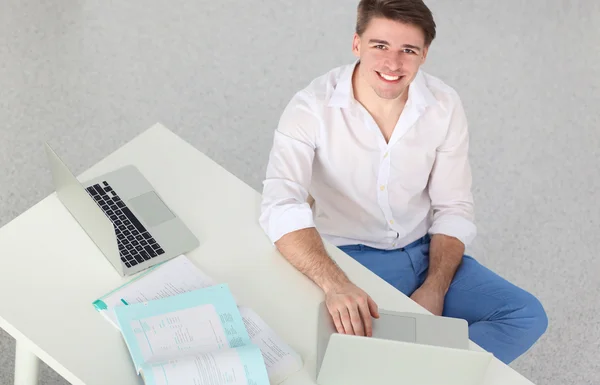 Joven hombre de negocios trabajando en la oficina, sentado cerca del escritorio — Foto de Stock