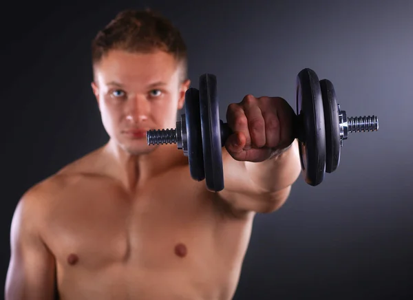 Schöner muskulöser Mann, der mit Hanteln trainiert — Stockfoto