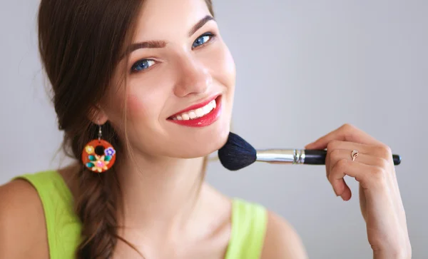 Young beautiful woman making make-up near mirror,sitting at the desk — Stock Photo, Image