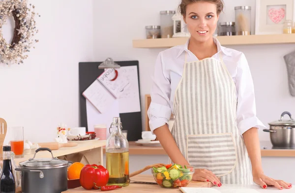 Smiling young woman standing  in the kitchen — Stock Photo, Image