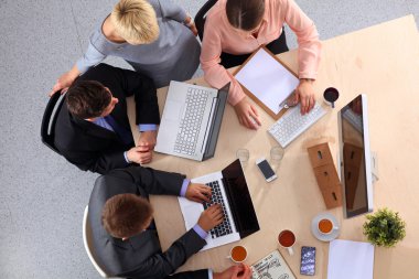 İş adamları iş toplantısında, ofiste oturup tartışıyorlar.