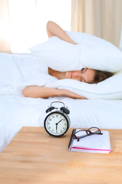 A young woman putting her alarm clock off in the morning — Stock Photo, Image