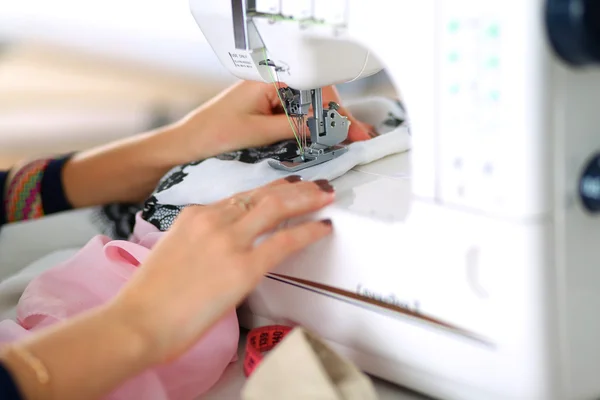 Jeune femme couture assis à son lieu de travail — Photo