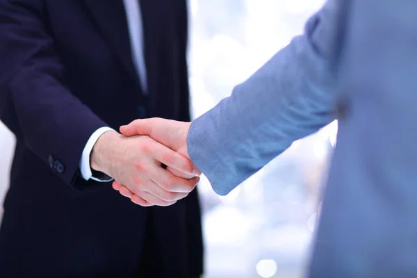 Бізнесмени тремтять руками, завершуючи зустріч — стокове фото