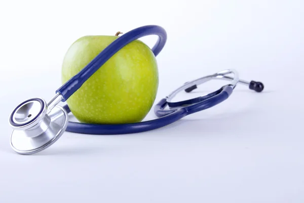 Stethoskop und grüner Apfel isoliert auf weißem Hintergrund — Stockfoto