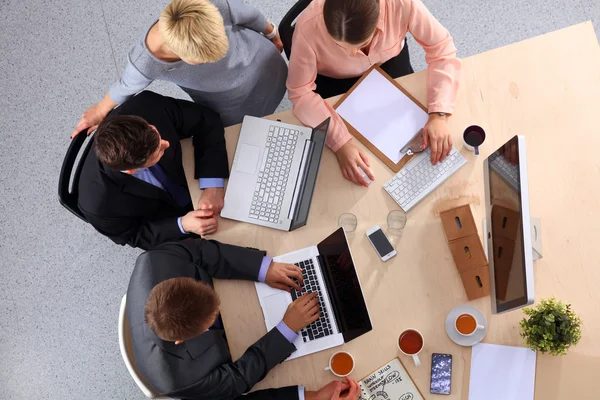 İş adamları iş toplantısında, ofiste oturup tartışıyorlar.