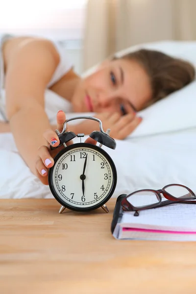 Молодая женщина откладывает будильник на утро Стоковое Изображение