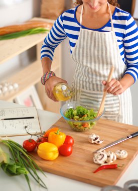 Genç kadın taze salata hazırlıyor.