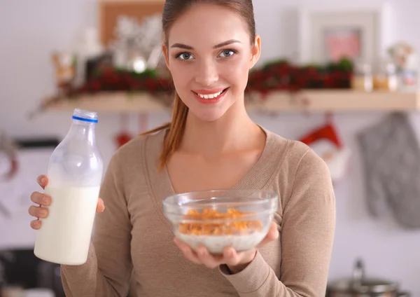 Uśmiechnięta atrakcyjna kobieta je śniadanie we wnętrzu kuchni — Zdjęcie stockowe