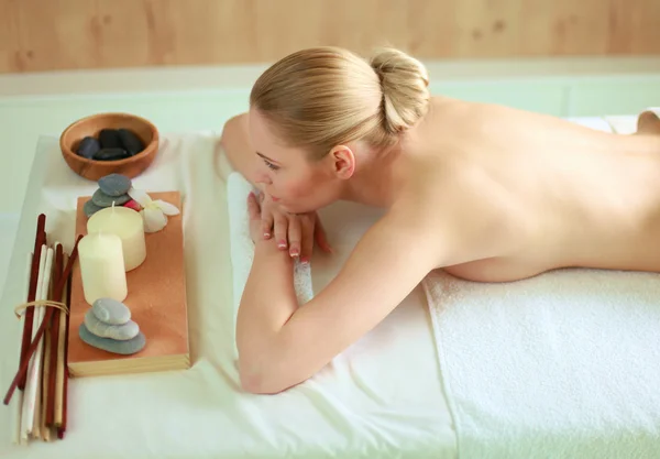 Красивая молодая женщина получает спа-массаж, лежа в салоне — стоковое фото