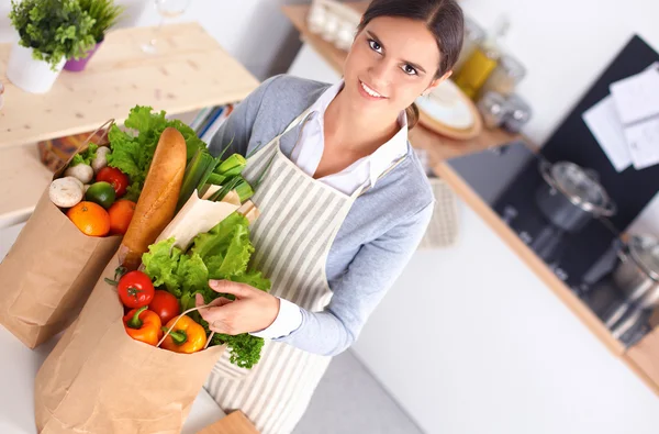 Kvinna att göra hälsosamma livsmedel stående leende i köket — Stockfoto