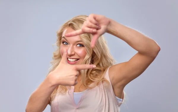 Young woman creating a frame with fingers — Stock Photo, Image