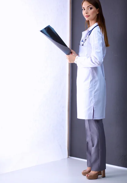 Female doctor with X-ray picture standing near grey wall — Stock Photo, Image