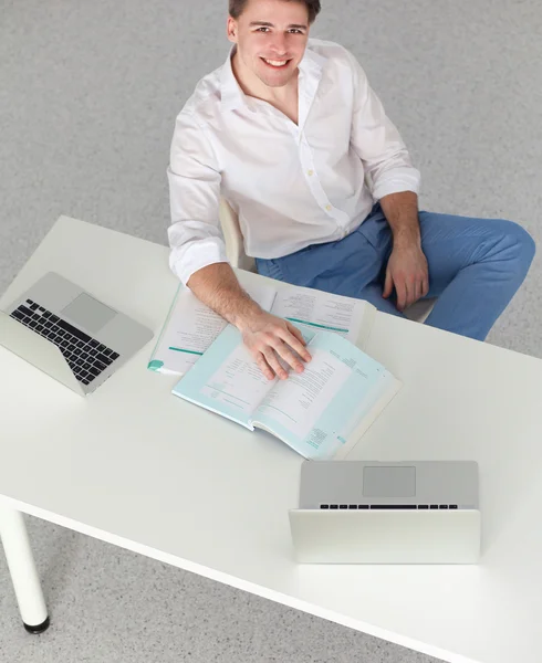 Mladý podnikatel pracují v kanceláři, sedící u stolu — Stock fotografie