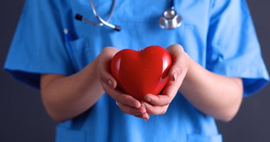 Steteskoplu doktor kalbi tutuyor.