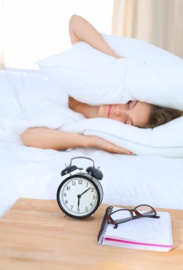 Genç bir kadın sabah alarmını erteliyor.