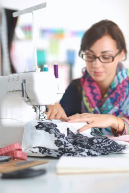 Çalışırken dikiş diken genç bir kadın.