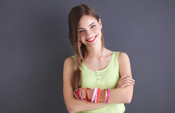 Mujer joven de pie cerca de la pared oscura — Foto de Stock