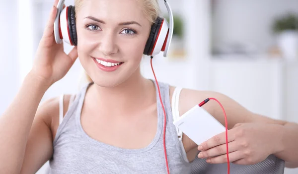 Joven hermosa mujer en casa sentada en el sofá y escuchando música —  Fotos de Stock