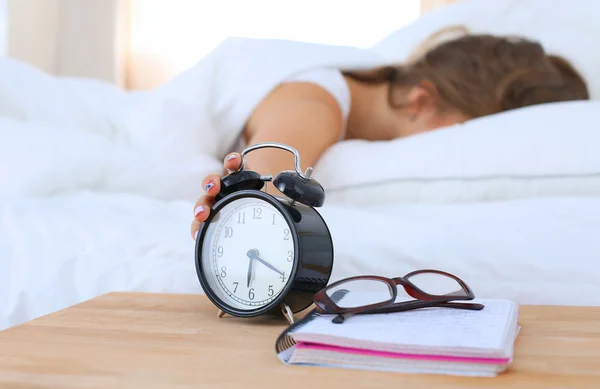 Una giovane donna che disattiva la sveglia la mattina — Foto Stock