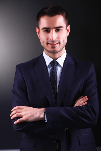 Retrato del joven sonriendo de pie sobre fondo gris —  Fotos de Stock