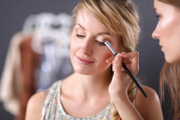 Художник, делающий профессиональный макияж женщины — стоковое фото