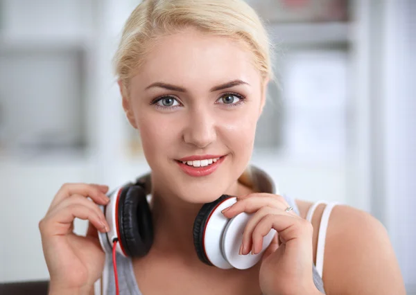 Joven hermosa mujer en casa sentada en el sofá y escuchando música —  Fotos de Stock