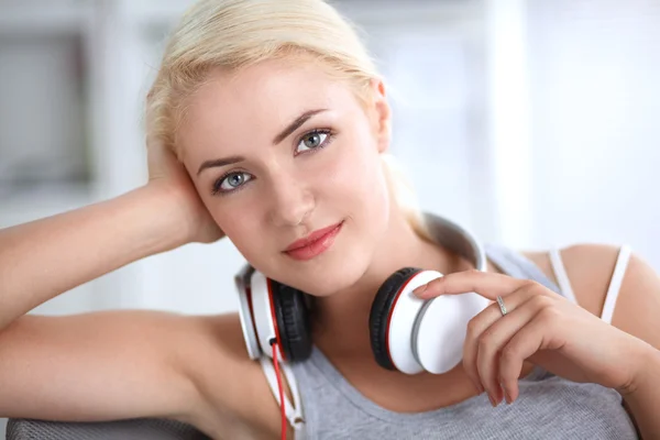 Young beautiful woman at home sitting on sofa and listening music — Stock Photo, Image