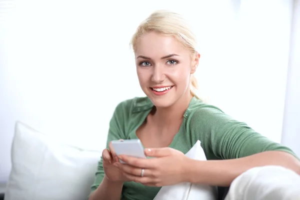 Bella donna nel suo salotto sdraiata sul divano che invia messaggi — Foto Stock