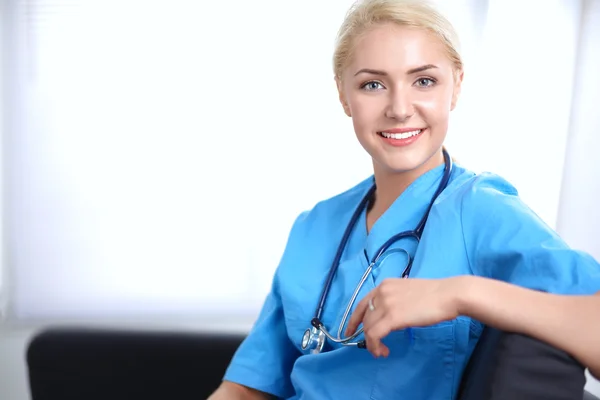 Portrait d'un jeune médecin heureux assis sur le canapé avec un dossier — Photo