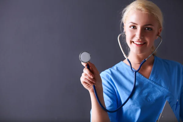 Médica feminina com estetoscópio ouvindo, isolada em fundo cinza — Fotografia de Stock