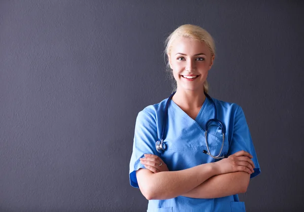 Mujer doctora joven con estetoscopio aislado sobre fondo gris —  Fotos de Stock