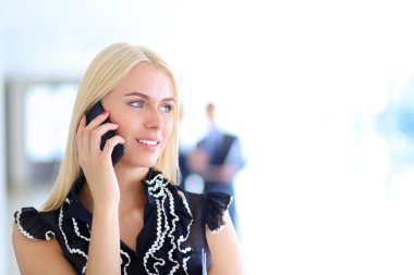 Ofiste cep telefonu kullanan güzel bir iş kadını.