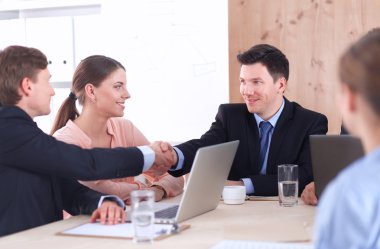 İş adamları iş toplantısında, ofiste oturup tartışıyorlar.