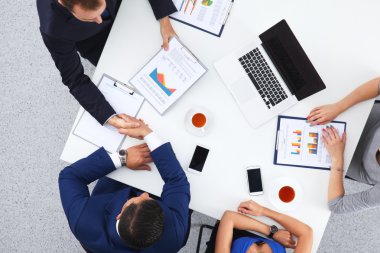 İş adamları iş toplantısında, ofiste oturup tartışıyorlar.