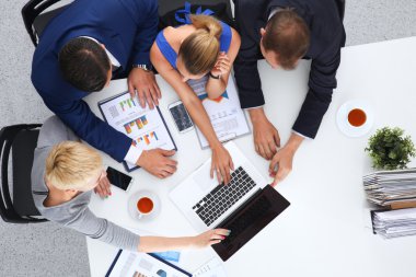 İş adamları iş toplantısında, ofiste oturup tartışıyorlar.